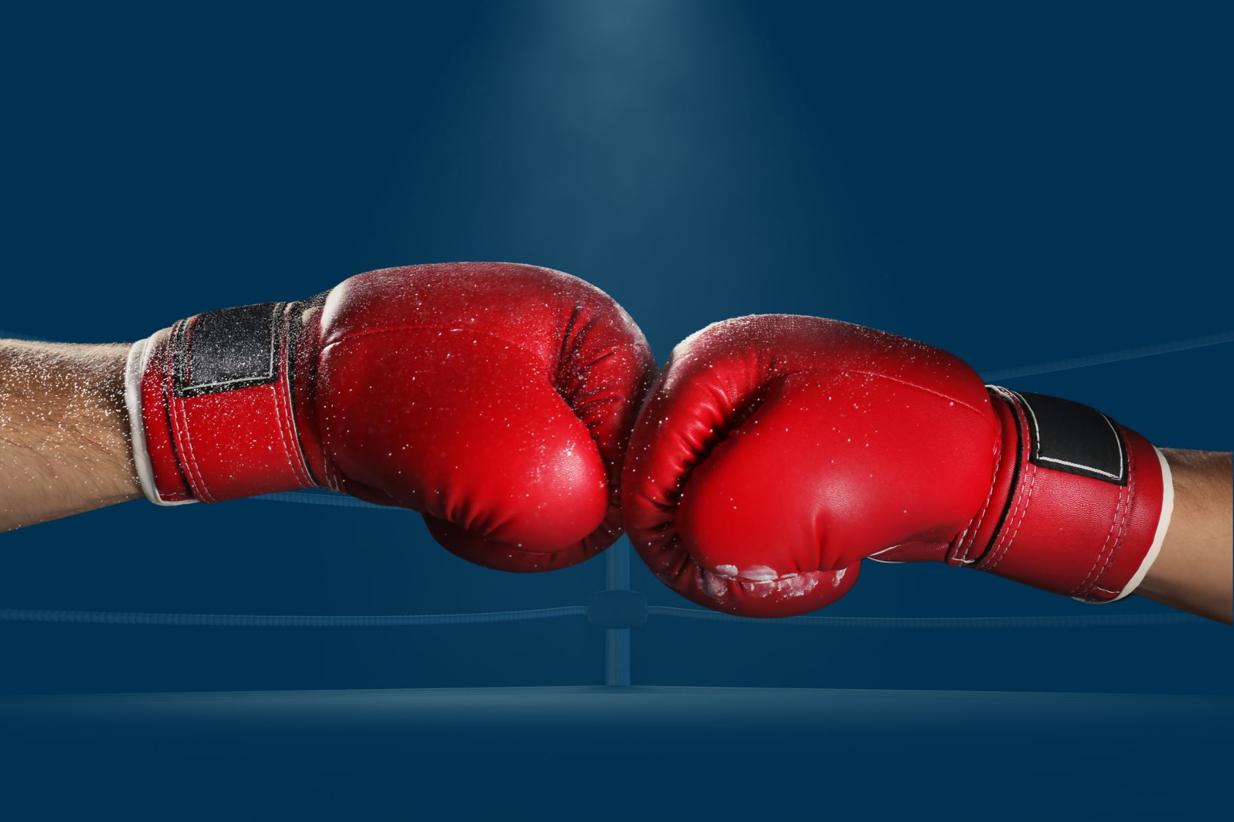 Red boxing gloves fist bumping each other.
